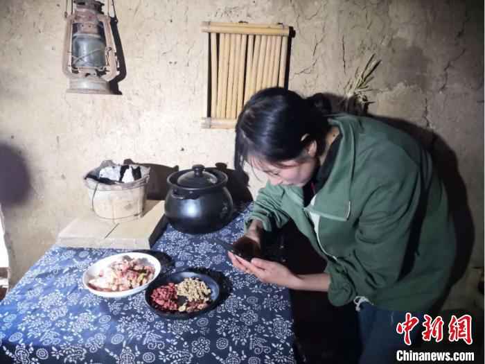 图为宕昌磨河坝村农家女,用手机录制烹饪“山味”的视频,与生活在都市的网友们分享。 后孝贤 摄 甘肃宕昌农家女引都市人“云入山”:烹山味直播荐土产
